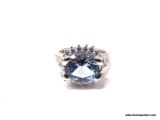 .925 STERLING SILVER RING WITH LARGE CENTER AQUAMARINE SURROUNDED BY SMALL CZ GEMSTONES. MADE BY