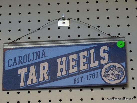CAROLINA TAR HEELS ADVERTISING SIGN; IS BLUE AND LIGHT BLUE IN COLOR. MEASURES 12 IN X 5.5 IN