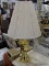 BRASS LAMP; BRASS TABLE LAMP WITH A HARP, SHADE, AND BRASS FINIAL. IS IN GOOD CONDITION AND MEASURES