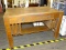 DESK; OAK DESK WITH A SINGLE DRAWER WITH BRASS PULLS, BUILT IN SIDE SHELVES AND A LOWER SHELF