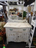 WASHSTAND; DISTRESSED FINISH WASHSTAND WITH AN UPPER TOWEL BAR, A LOWER DRAWER AND 2 DOORS. IS IN