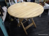 ROUND FOLDING TABLE; MAPLE FOLDING TABLE IN VERY GOOD CONDITION. HAS AN X-SHAPED BASE AND MEASURES