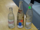 3 BOTTLE LOT; INCLUDES A NEHI BOTTLE, A VINTAGE PEPSI BOTTLE WITH PAPER LABEL, AND A BAINS BOTTLE