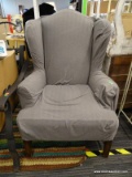 WING CHAIR; PINK UPHOLSTERED WING BACK CHAIR WITH A GRAY SLIP COVER. HAS MAHOGANY LEGS AND A