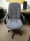 (RM11) GREY UPHOLSTERED ROLLING OFFICE CHAIR. TILTS TO ONE SIDE.