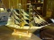 (RM8) BRASS MODEL SHIP ON WOODEN STAND. MEASURE 20