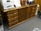 (RM9) VINTAGE WOODGRAIN CREDENZA WITH 86 DRAWER AND 2 CENTER DOORS THAT OPEN TO A CENTER SHELF. HAS