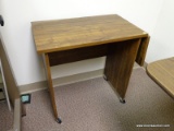 (RM2) WOOD GRAIN ROLLING MICROWAVE CART WITH DROP SIDE. MEASURES 36