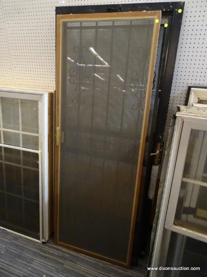 SCREEN DOOR; BROWN CASED SCREEN DOOR. MEASURES 29 IN X 78 IN