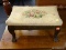 FOOTSTOOL WITH FLORAL UPHOLSTERED TOP. MEASURES 14 IN X 9 IN X 8 IN. ITEM IS SOLD AS IS WHERE IS