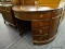 MAHOGANY DEMILUNE DESK WITH 4 SIDE DRAWERS ON EITHER SIDE AND A CENTER DRAWER. MEASURES 45 IN X 23