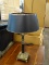 BRASS AND BLACK BASE TABLE LAMP WITH BLACK SAHDE, DOUBLE LIGHTS, AND HOOP STYLE FINIAL. MEASURES 31