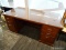 CHERRY DOUBLE PEDESTAL DESK WITH 6 DRAWERS (2 ARE FILING) AND BRASS DRAWER PULLS. HAS A GLASS