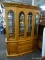 SUMTER FURNITURE OAK CHINA CABINET WITH BRASS PULLS AND BEVELED GLASS UPPER DOORS. HAS 4 UPPER