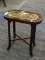 END TABLE WITH BRASS INSERT IN THE TOP. HAS A CROSS-STRETCHER BASE AND MEASURES 9.5 IN X 17.5 IN X