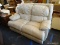 CREAM COLORED LEATHER OVERSTUFFED DOUBLE RECLINER. MEASURES 61 IN X 41 IN X 42 IN. MATCHES #44. SOLD