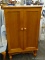 CHERRY 2 DOOR STORAGE CABINET. DOORS OPEN TO REVEAL EXTRA STORAGE. MEASURES 24 IN X 13 IN X 41 IN.