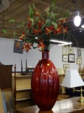 RED DECORATIVE VASE WITH A RED AND YELLOW FLORAL ARRANGEMENT. MEASURES 45 IN TALL. SOLD AS IS, WHERE