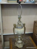 GOLD TONED URN SHAPED LAMP WITH ACORN STYLE FINIAL AND BRASS HARP. MEASURES 34.5 IN TALL. ITEM IS