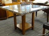 FAUX MARBLE TOP HIGH TOP TABLE WITH, GLASS PROTECTIVE TOP, MAHOGANY BASE AND LOWER SHELF. MEASURES