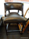 HIGH-TOP CHAIR WITH BLACK LEATHER UPHOLSTERY AND BRASS STUDDING. MEASURES 21 IN X 22 IN X 36 IN.