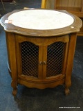 ROUND MARBLE TOP END TABLE WITH 2 LATTICE PATTERN DOORS. MEASURES 26 IN X 24 IN. SOLD AS IS, WHERE