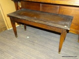 PIANO BENCH WITH LIFT TOP THAT OPENS TO REVEAL INTERIOR STORAGE. MEASURES 38 IN X 16 IN X 19 IN.