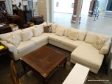 MODERN SECTIONAL SOFA WITH CREAM COLORED UPHOLSTERY AND MAHOGANY LEGS. MEASURES 142 IN X 108 IN X 36