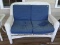 (BCK PRCH) WHITE WICKER BENCH WITH BLUE UPHOLSTERED CUSHIONS. MEASURES 49 IN X 35 IN X 35 IN. ITEM