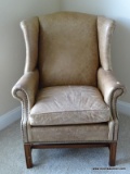 (BED 2) LEATHER UPHOLSTERED WING CHAIR WITH BRASS STUDDING AROUND THE ARMS. MEASURES 32 IN X 32 IN X