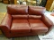 ASHLEY HOME FURNITURE OXBLOOD RED LEATHER UPHOLSTERED LOVESEAT. MEASURES 60 IN X 36 IN X 34 IN. ITEM