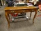 OAK CONSOLE TABLE WITH QUEEN ANNE FEET AND SERPENTINE SKIRT. MEASURES 48 IN X 16 IN X 30.5 IN. ITEM