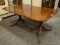 DOUBLE PEDESTAL MAHOGANY DINING ROOM TABLE WITH BRASS CAPPED FEET. MEASURES APPROXIMATELY 63 IN X 46