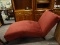 BURGUNDY UPHOLSTERED CHAISE LOUNGE CHAIR WITH MAHOGANY LEGS. MEASURES 27 IN X 60 IN X 33 IN. ITEM IS