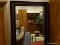 FRAMED AND BEVELED GLASS MIRROR. HAS A BLACK AND BROWN TONED FRAME AND MEASURES 30.5 IN X 64 IN.