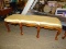 SOLID MAHOGANY AND GOLD TONE FABRIC UPHOLSTERED BENCH. MEASURES 64 IN X 21 IN X 22 IN. ITEM IS SOLD