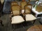 SET OF 4 PECAN FINISH ARM DINING CHAIRS WITH CREAM UPHOLSTERED SEATS AND CANE BACKS. ARE ON CASTERS