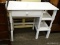 WHITE PAINTED SINGLE DRAWER KNEE HOLE DESK WITH SIDE SHELVING AREA. MEASURES 36 IN X 18 IN X 30.5
