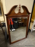 MAHOGANY FRAMED MIRROR WITH BROKEN ARCH PEDIMENT TOP AND CENTER FINIAL. MEASURES 32.5 IN X 53 IN.
