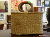 HAND WOVEN LADIES PURSE WITH WOODEN HANDLES. MEASURES 11 IN X 10.5 IN. ITEM IS SOLD AS IS WHERE IS