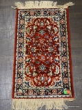 SMALL AREA RUG IN HUES OF RED, BLUE, AND CREAM. MEASURES 1 FT 4 IN X 2 FT 5 IN. ITEM IS SOLD AS IS