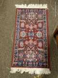 SMALL AREA RUG IN HUES OF BURGUNDY, GREEN, AND BLUE. MEASURES 2 FT 8 IN X 3 FT 2 IN. ITEM IS SOLD AS