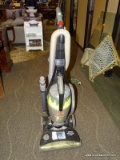 BISSELL HEAVY DUTY VACUUM CLEANER IN GRAY AND GREEN. HAS A BUTTON ON THE HANDLE TO START AND UP TO
