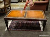 MAHOGANY COFFEE TABLE WITH GOLD TONE STENCILING AROUND THE EDGE OF THE TOP PANELS AND ROPED EDGING.