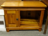 CHERRY ENTERTAINMENT STAND WITH 1 DOOR AND 1 SIDE STORAGE AREA WITH SHELF. DOOR OPENS TO REVEAL AN