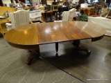 ROUND MAHOGANY DINING TABLE WITH A PEDESTAL BASE WITH SCROLLING FEET. MEASURES 54 IN X 29.5 IN. ITEM