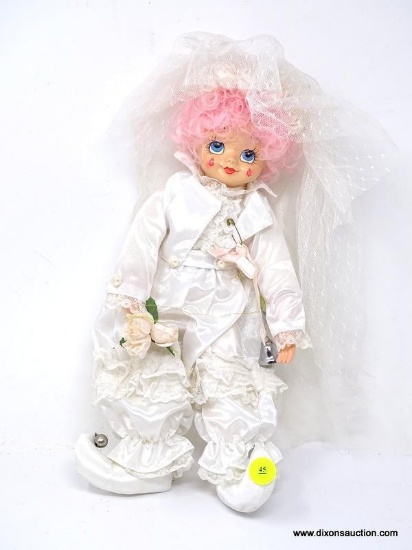 VINTAGE BRINN'S JESTER IN A WHITE OUTFIT WITH BELLS AND FLOWERS. MEASURES 12 IN TALL. ITEM IS SOLD