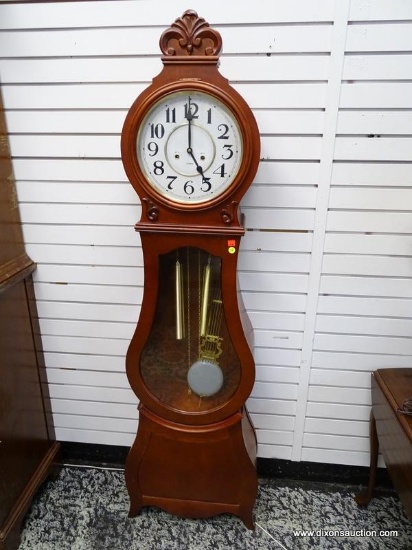 CHERRY CASE 31 DAY GRANDMOTHER CLOCK WITH CARVED CREST, WEIGHTS, AND PENDULUM. MEASURES 19.5 IN X 9