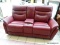 OXBLOOD RED LEATHER UPHOLSTERED POWER RECLINING LOVESEAT WITH CENTER CONSOLE THAT OPENS TO REVEAL