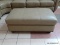 BRAND NEW TOP GRAIN LEATHER TAUPE OTTOMAN BY ABBYSON. HAS BRASS STUDDED ACCENTS ALONG THE EDGE AND